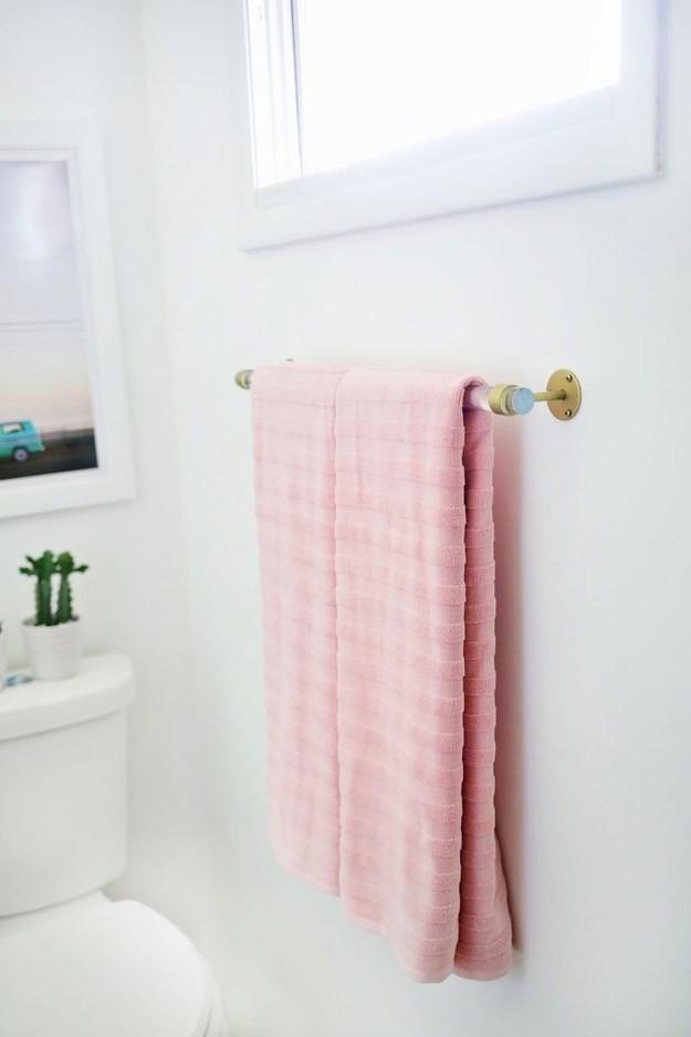 Custom towel rack can be made of old curtain holders.